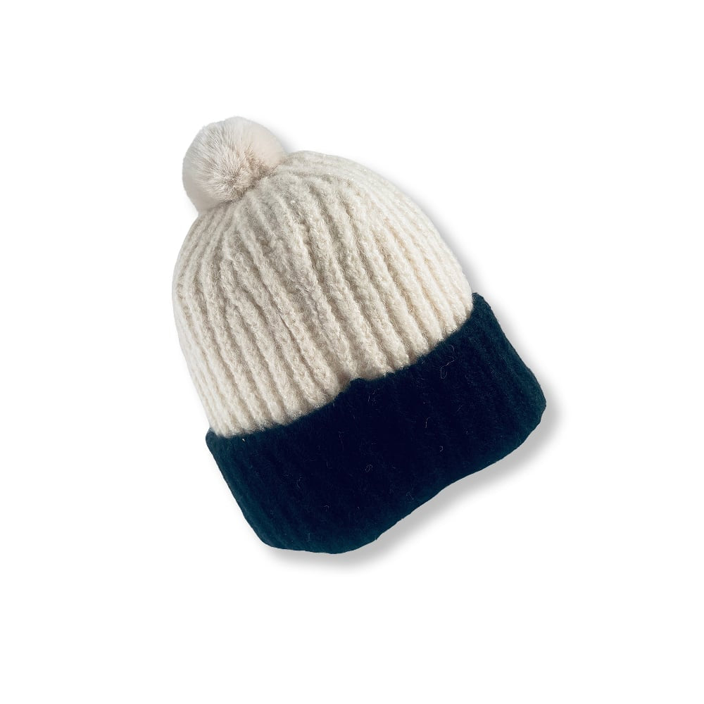 Trendy strikkelue med dusk og brettekant